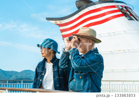 フェリーのデッキで双眼鏡を覗くシニア夫婦と フェリーのデッキで双眼鏡を覗くシニア夫婦と 133863853