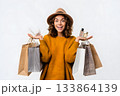Woman smiles holding shopping bags and perfume bottles. 133864139