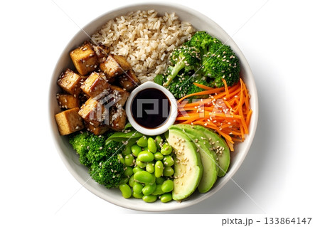 A vegan bowl features rice, tofu, broccoli, avocado, edamame, and carrots. A vegan bowl features rice, tofu, broccoli, avocado, edamame, and carrots. 133864147