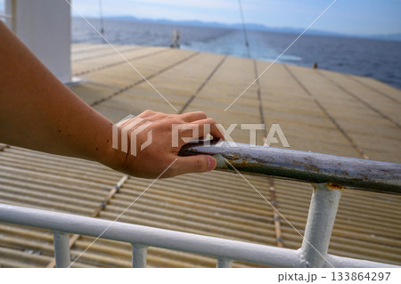 フェリーデッキで海を眺める手 133864297