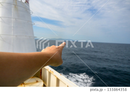 隠岐の島へ向かうフェリーから海と島を指し示 隠岐の島へ向かうフェリーから海と島を指し示 133864358
