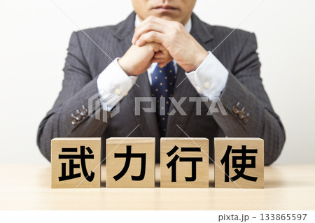 「武力行使」と書かれたブロックとビジネスマン 「武力行使」と書かれたブロックとビジネスマン 133865597