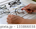 複数のメガネの中から選ぶ日本人男性の手元 133866038