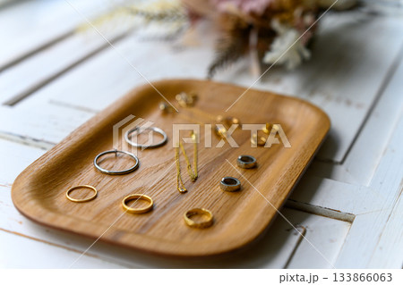 木製トレイに置かれたゴールドとシルバーの指 133866063