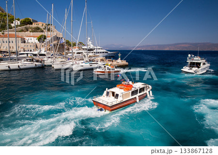 Awe  view on Boat - water taxi   at  island with harbor with ssailboats behind.   Hydra island  - best of Greek islands 133867128