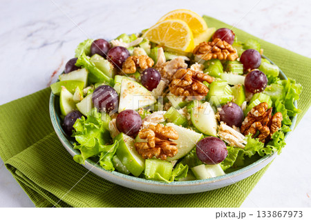 Fresh Waldorf salad, celery stalk with chicken, apple and walnuts, grapes, herbs, homemade, without people, 133867973