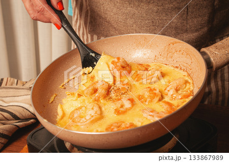 Cooking shrimp in a creamy sauce on a stovetop in a cozy kitchen during a sunny afternoon Cooking shrimp in a creamy sauce on a stovetop in a cozy kitchen during a sunny afternoon 133867989