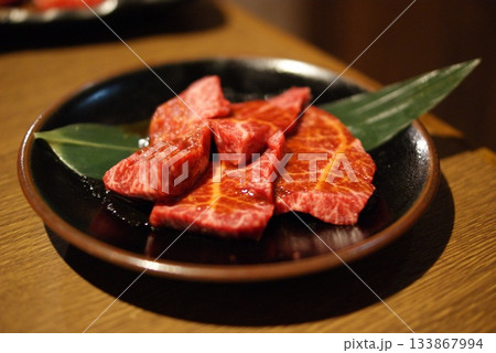 藁と笹で演出した高級感あふれる霜降り赤身肉の黒皿  133867994