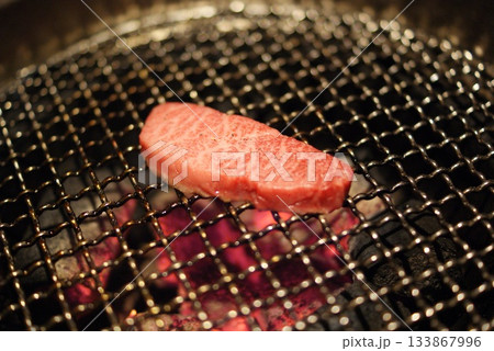炭火の網で焼き上げるジューシーな霜降り赤身肉のシズルショット 炭火の網で焼き上げるジューシーな霜降り赤身肉のシズルショット 133867996