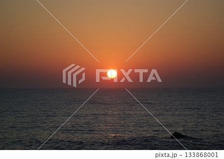 ススキのシルエット越しに見る秋の赤橙色の海面に沈む夕日 ススキのシルエット越しに見る秋の赤橙色の海面に沈む夕日 133868001