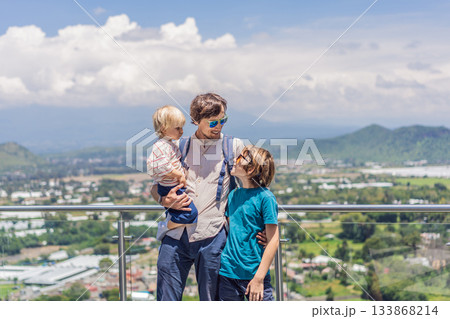 Father with his two sons standing in front of Popocatepetl volcano in Mexico, surrounded by clouds, enjoying a scenic family adventure and breathtaking outdoor view Father with his two sons standing in front of Popocatepetl volcano in Mexico, surrounded by clouds, enjoying a scenic family adventure and breathtaking outdoor view 133868214