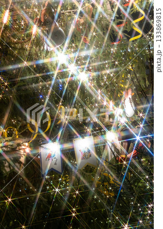Christmas tree with yellow ribbon, toys. Christmas tree decorated with garlands lots of sparkles. Christmas tree with yellow ribbon, toys. Christmas tree decorated with garlands lots of sparkles. 133869815