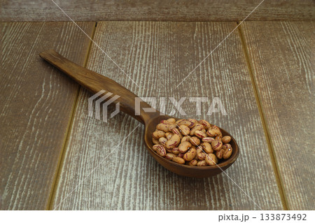 red kidney beans in wooden spoon isolated on dark background. 133873492