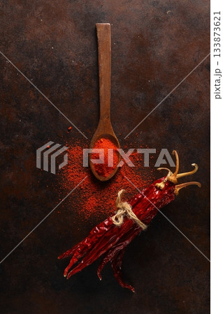 cayenne pepper on wooden spoon spices and dried chilli peppers background. cayenne pepper on wooden spoon spices and dried chilli peppers background. 133873621