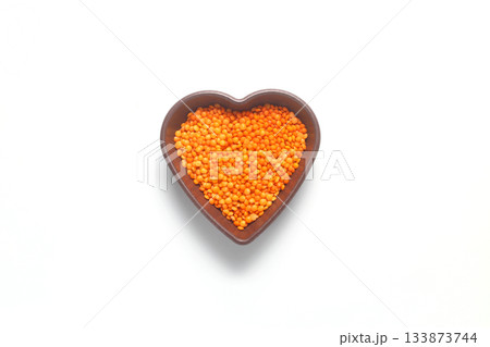 Pile red lentil in shape of heart isolated on white background. Top view. Flat lay. 133873744