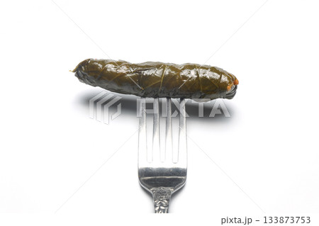 stuffed grape leaves on a fork on a white background. Stuffed collard greens with boiled leaves, 133873753