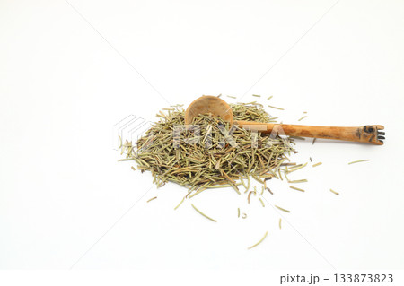 Closeup of dried rosemary on a wooden spoon isolated over white background. Closeup of dried rosemary on a wooden spoon isolated over white background. 133873823