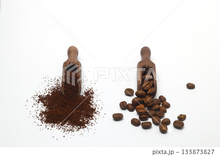 Coffee beans in a wooden scoop isolated on a white background. Roasted coffee beans isolated. A wooden scoop with coffee. 133873827