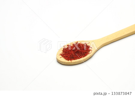 top view of crocus saffron threads in wood spoon isolated on white background 133873847