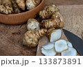Fresh Sliced Jerusalem Artichokes on Wooden Cutting Board 133873891