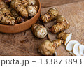 Fresh Sliced Jerusalem Artichokes on Wooden Cutting Board 133873893