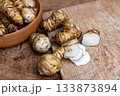 Fresh Sliced Jerusalem Artichokes on Wooden Cutting Board 133873894
