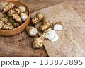 Fresh Sliced Jerusalem Artichokes on Wooden Cutting Board 133873895