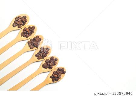 Coffee beans in a wooden spoon isolated on a white background. Roasted coffee beans isolated. A wooden spoon with coffee. 133873946