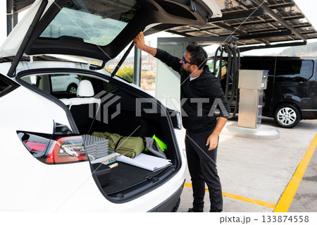 Male adult wipe the car with a cloth after washing. Male adult wipe the car with a cloth after washing. 133874558