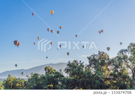 Colorful hot air balloons floating over Teotihuacan in Mexico, creating a breathtaking view of the ancient pyramids. Tourism, adventure, and cultural heritage concept Colorful hot air balloons floating over Teotihuacan in Mexico, creating a breathtaking view of the ancient pyramids. Tourism, adventure, and cultural heritage concept 133874706