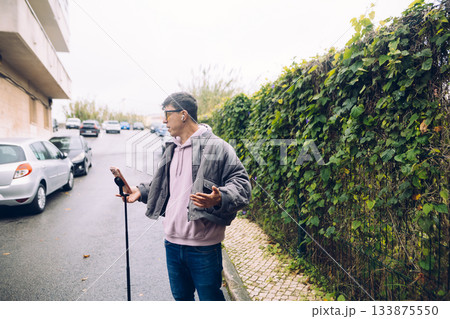 Photographer examines gear near urban dwellings and vehicles 133875550