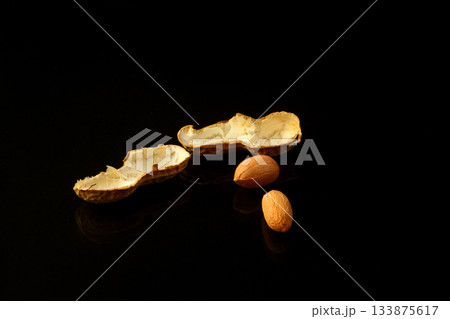 Peanut on glossy black surface with reflection. Group of peanuts isolated on black backgrounds 133875617