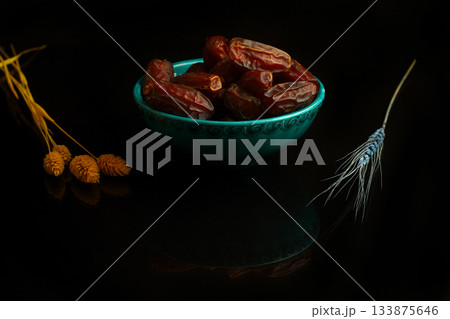 Dried dates on a wooden table in silver dishes close-up. Composition of dried dates in ramadan dish Dried dates on a wooden table in silver dishes close-up. Composition of dried dates in ramadan dish 133875646