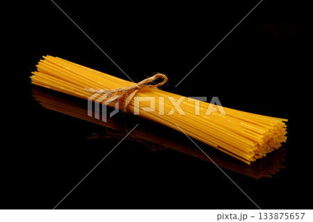 Spaghetti isolated on black background. Long italian pasta on white. Spaghetti isolated on black background. Long italian pasta on white. 133875657
