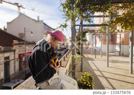 Teenager in pink hat reviews cityscape from balcony edge Teenager in pink hat reviews cityscape from balcony edge 133875676