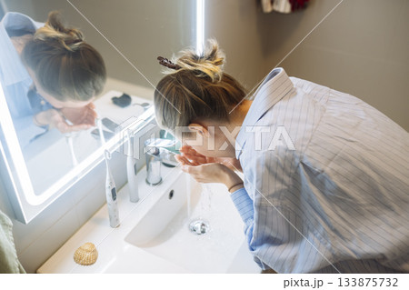 She methodically scrub her face to ensure cleanliness and freshness She methodically scrub her face to ensure cleanliness and freshness 133875732