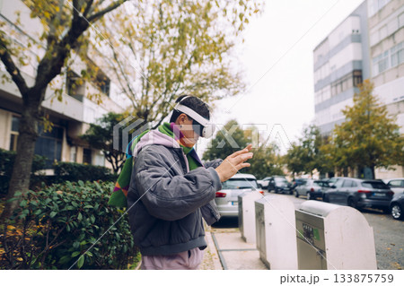 Adult individual interacting with virtual technology near residence 133875759