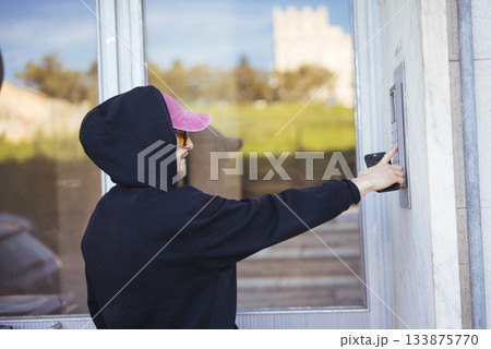 Person utilizing keypad to access structure during evening hours Person utilizing keypad to access structure during evening hours 133875770