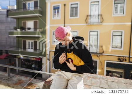Tender shot of individual and puppy enjoying sunny rooftop companionship 133875785