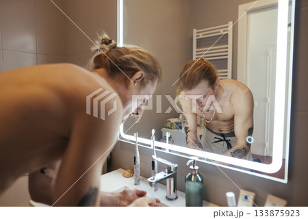 Person calmly examines how they present themselves visually Person calmly examines how they present themselves visually 133875923