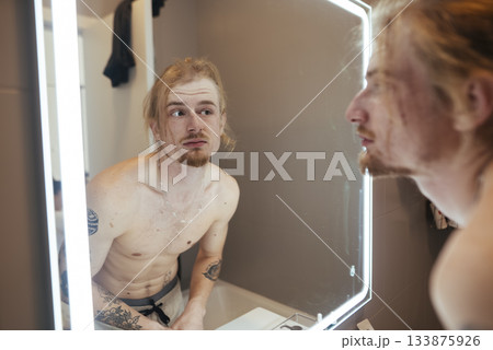Hesitant individual reviews tattoos carefully before departing 133875926