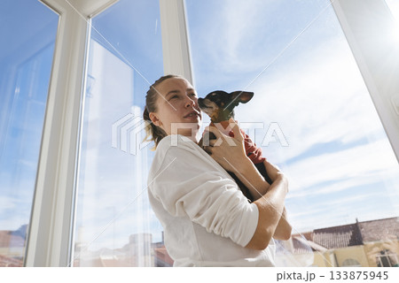Affectionate woman displaying trust with vibrant feathered companion 133875945