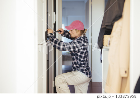 Beginner lock technician engaged in door security training Beginner lock technician engaged in door security training 133875959