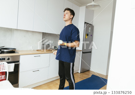 Male athlete practicing weightlifting in welllit kitchen environment Male athlete practicing weightlifting in welllit kitchen environment 133876250