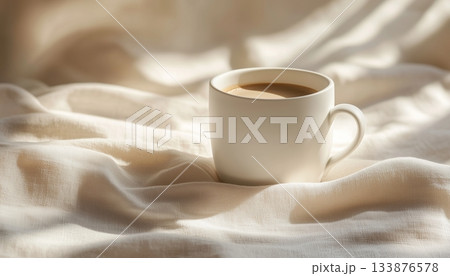 Hot coffee cup on white mug and satin textile aesthetic background 133876578
