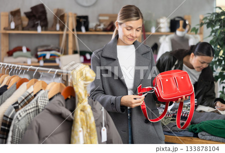 Adult woman choosing handbag in clothing store 133878104