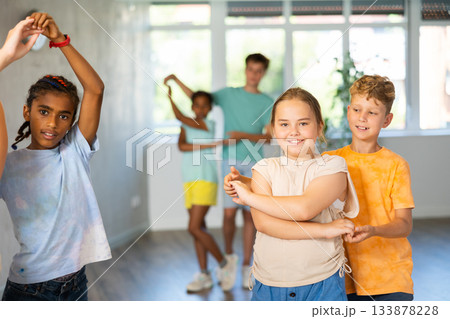 Portrait of girl with boy performing pair dance movements Portrait of girl with boy performing pair dance movements 133878228