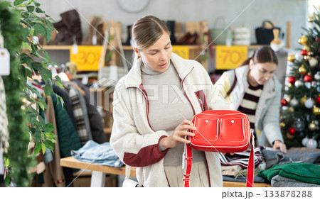 Adult woman choosing handbag in clothing store Adult woman choosing handbag in clothing store 133878288