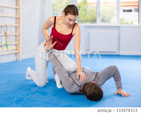 Young girl and middle-aged man practicing arm twist technique during self-defense courses Young girl and middle-aged man practicing arm twist technique during self-defense courses 133878313