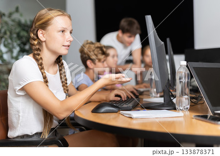 Girl student learning to work on computer in classroom Girl student learning to work on computer in classroom 133878371